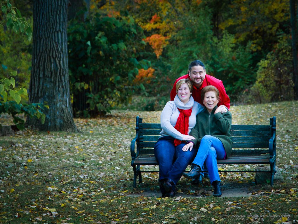 Family portrait of three on park bench